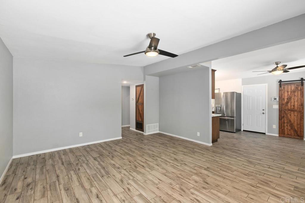 1451 Gowin Street Spring Valley, CA 91977 - Photo 5 of 24 a view of a livingroom with wooden floor and a ceiling fan