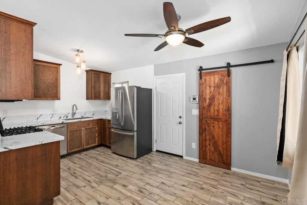 1451 Gowin Street Spring Valley, CA 91977 - Photo 6 of 24 a kitchen with stainless steel appliances granite countertop a refrigerator a stove a sink and a refrigerator with wooden floor