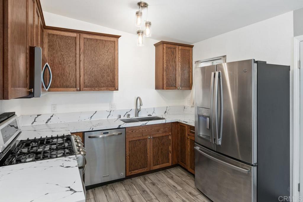 1451 Gowin Street Spring Valley, CA 91977 - Photo 9 of 24 a kitchen with stainless steel appliances granite countertop a refrigerator and a sink