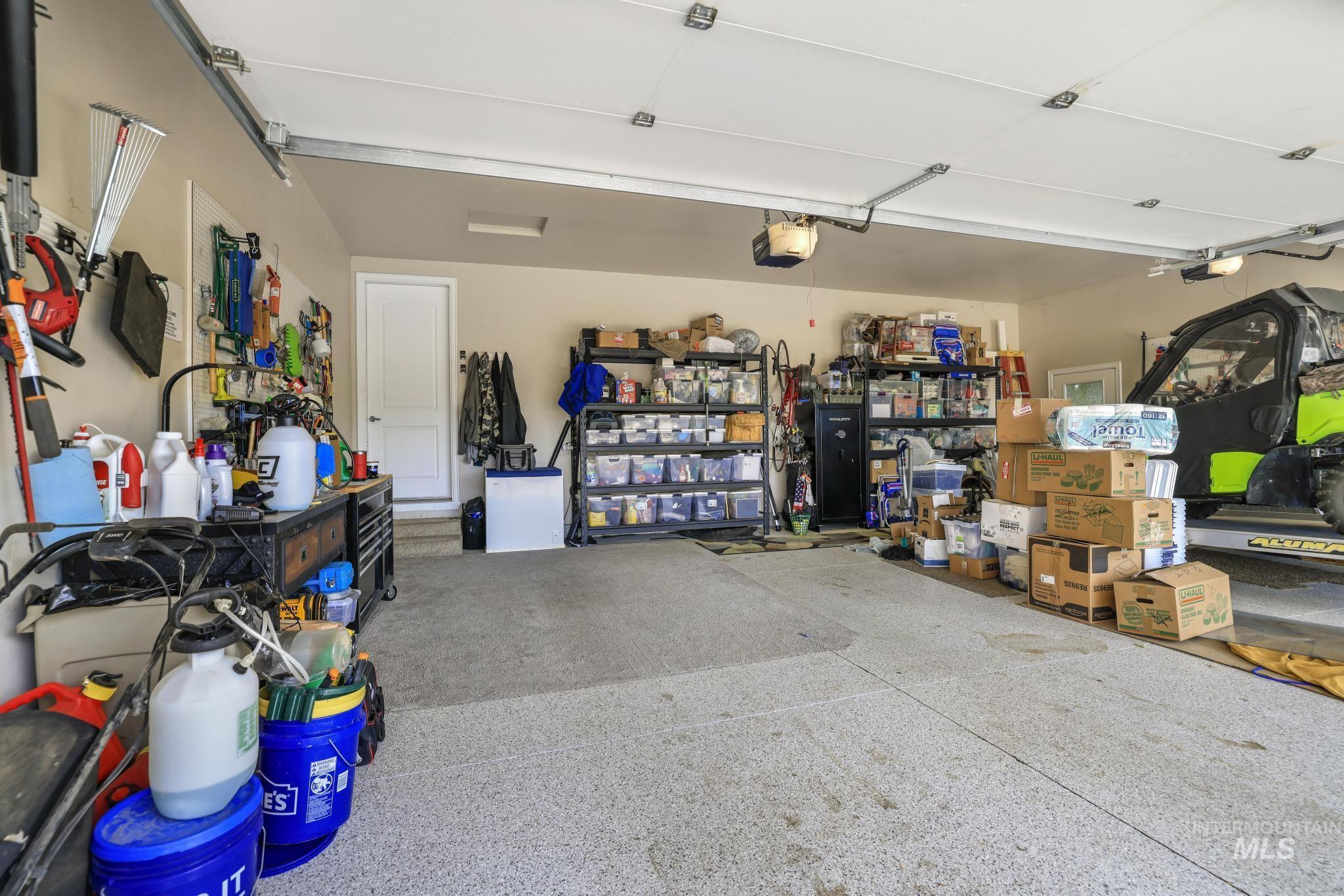 100 Olympic Road Jerome, ID 83338 - Photo 31 of 50 Spacious garage featuring a durable epoxy-coated concrete floor, overhead lighting, and white paneled interior door