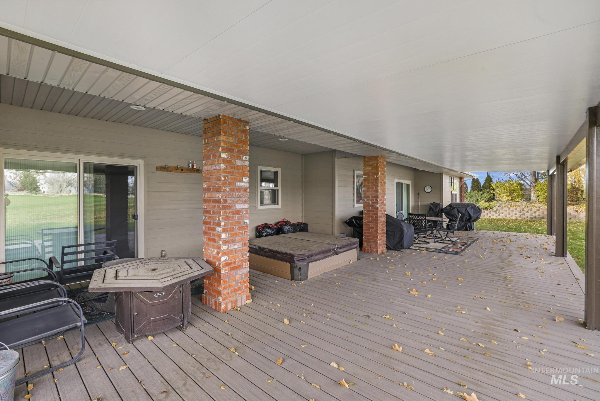 100 Olympic Road Jerome, ID 83338 - Photo 33 of 50 Spacious covered deck featuring composite decking, recessed lighting, brick-clad support columns, and sliding glass door access