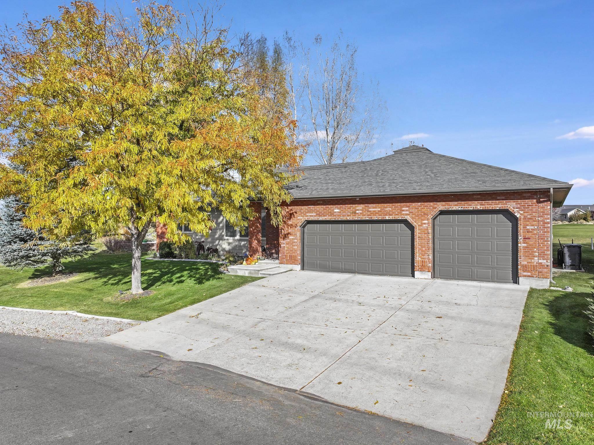 100 Olympic Road Jerome, ID 83338 - Photo 50 of 50 Brick exterior featuring a two-car garage with panel doors and a paved driveway