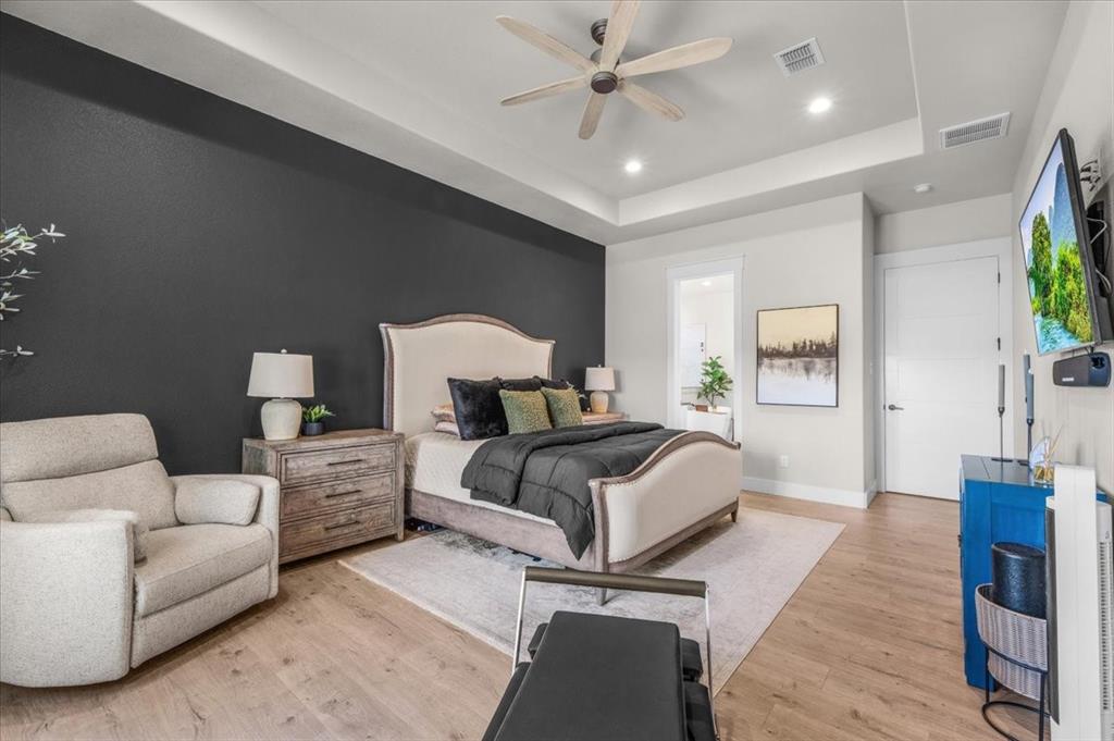 1059 Sweeney Way Weatherford, TX 76087 - Photo 12 of 37 Primary room featuring a tray ceiling with a ceiling fan, recessed lighting, roller shades and accent wall.