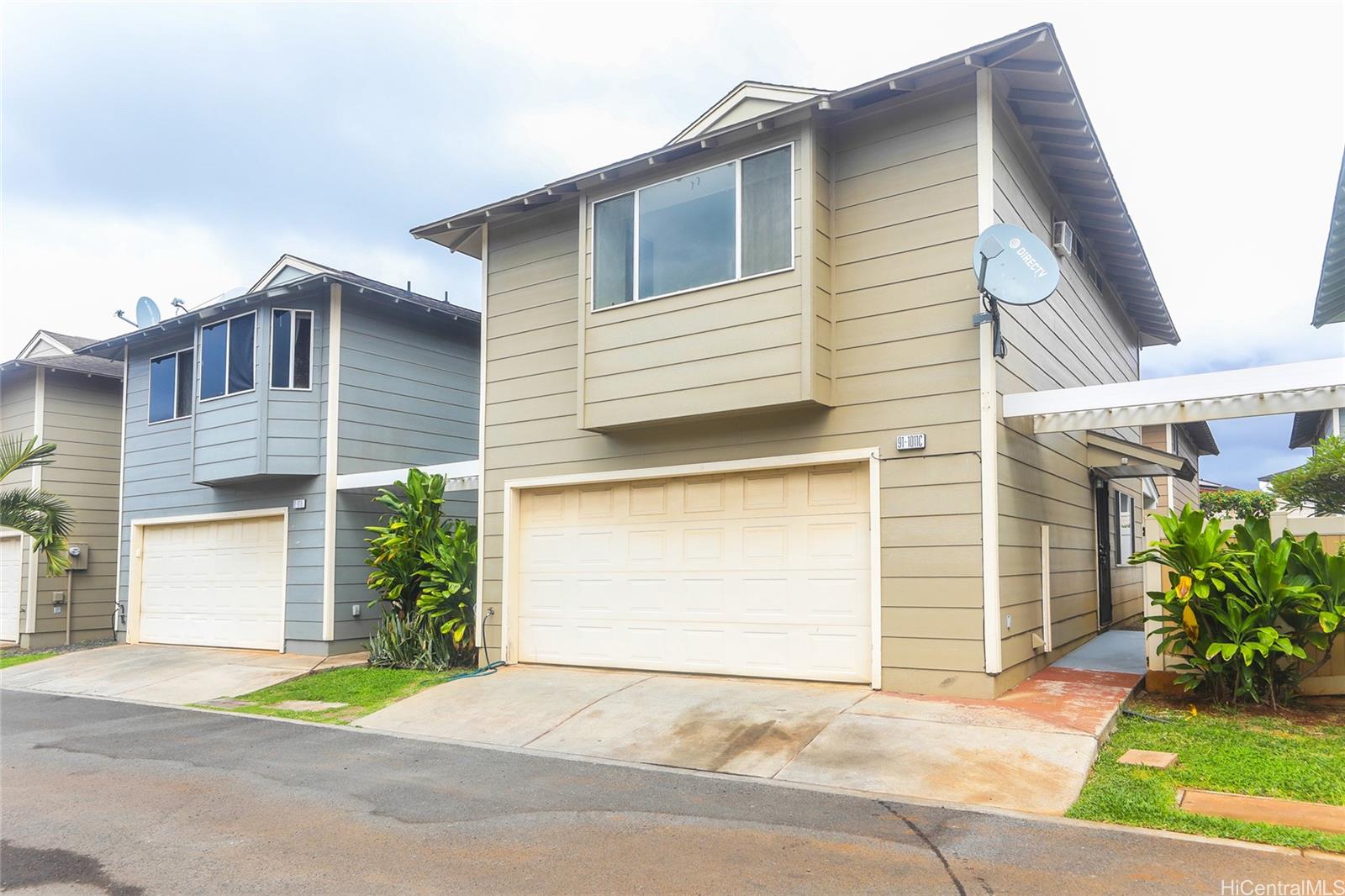 91-1011 Laulauna Street, Unit 136 Ewa Beach, HI 96706 - Photo 1 of 25 a front view of a house with a yard and garage