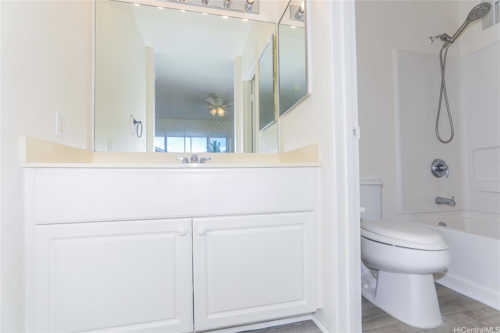 91-1011 Laulauna Street, Unit 136 Ewa Beach, HI 96706 - Photo 14 of 25 a bathroom with a shower a toilet and sink