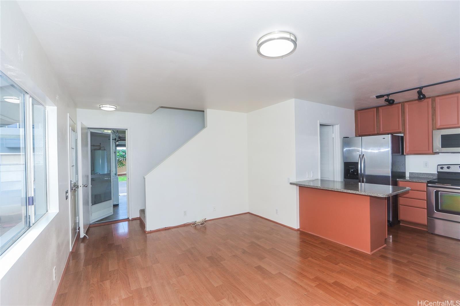 91-1011 Laulauna Street, Unit 136 Ewa Beach, HI 96706 - Photo 2 of 25 a kitchen with stainless steel appliances a refrigerator and a stove top oven