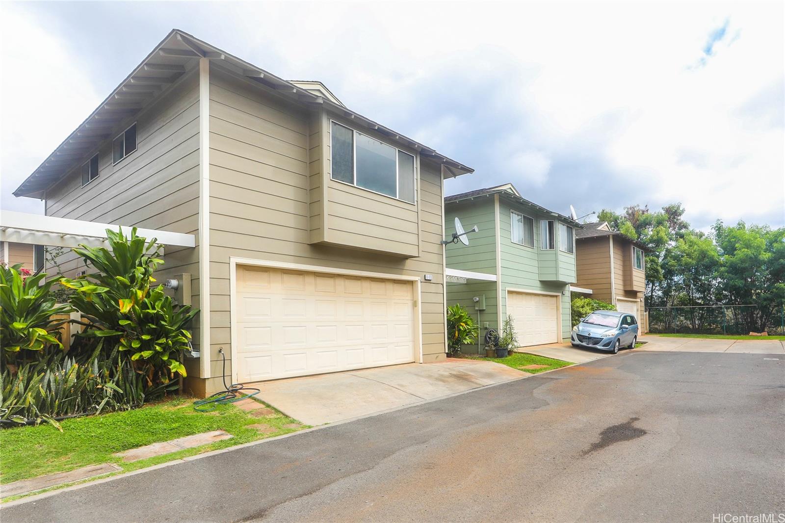 91-1011 Laulauna Street, Unit 136 Ewa Beach, HI 96706 - Photo 25 of 25 a view of a house with a yard and garage