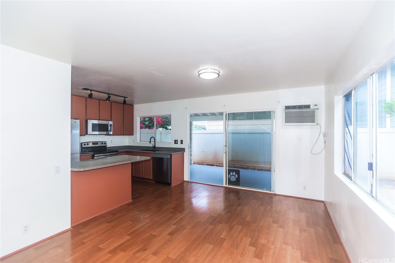 91-1011 Laulauna Street, Unit 136 Ewa Beach, HI 96706 - Photo 4 of 25 a kitchen with stainless steel appliances granite countertop a refrigerator and a stove top oven