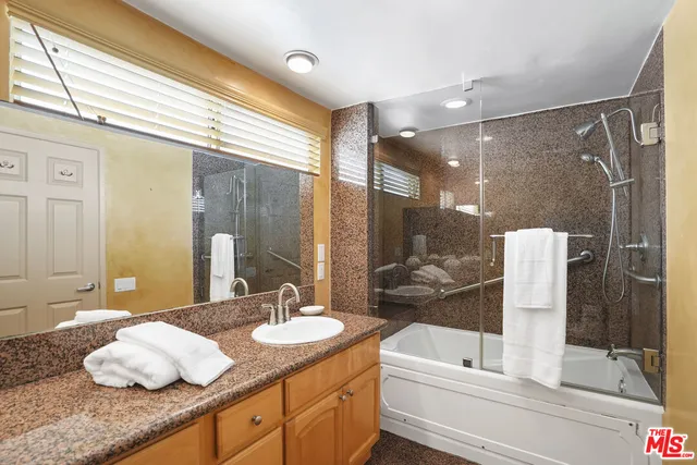 a bathroom with a granite countertop sink and a mirror