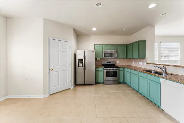 a kitchen with stainless steel appliances a refrigerator sink and microwave