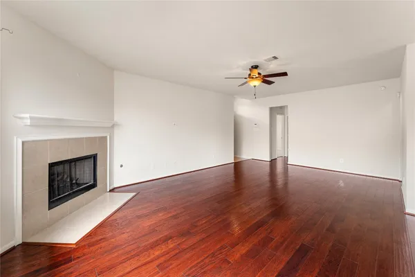 a view of empty room with wooden floor and fireplace