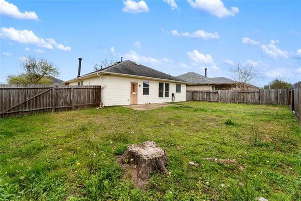 a white house with a big yard and large trees