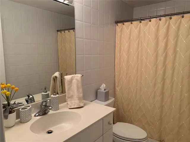 a bathroom with a sink a toilet and shower curtain