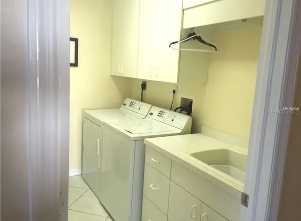 a utility room with a sink and washing machine