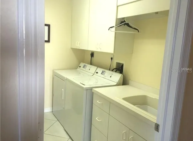 a utility room with a sink and washing machine
