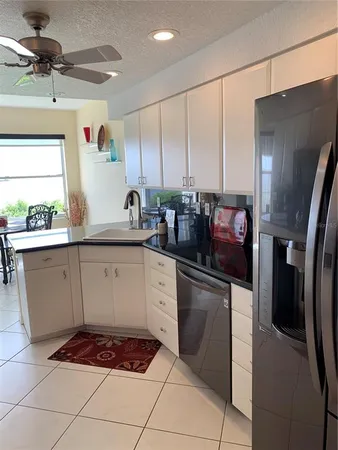 a kitchen with stainless steel appliances kitchen island granite countertop a sink stove and refrigerator