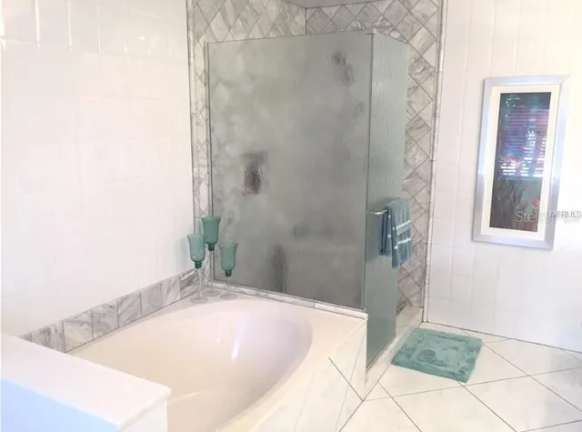 a bathroom with a tub shower and sink