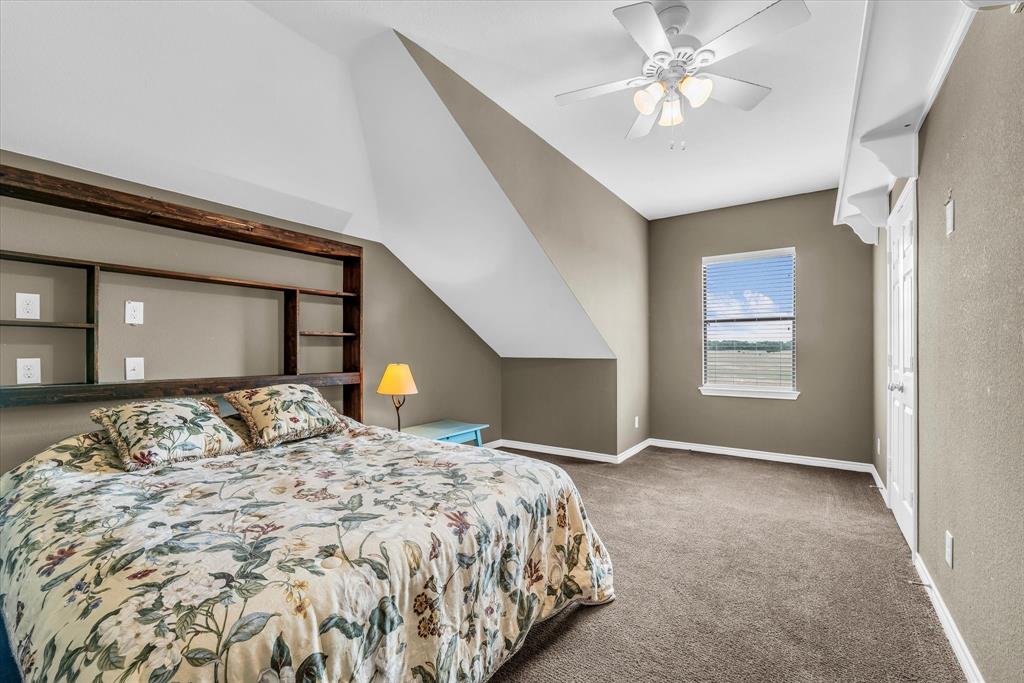 613 Bone Road Valley Mills, TX 76689 - Photo 19 of 40 a bedroom with a large bed and a chandelier