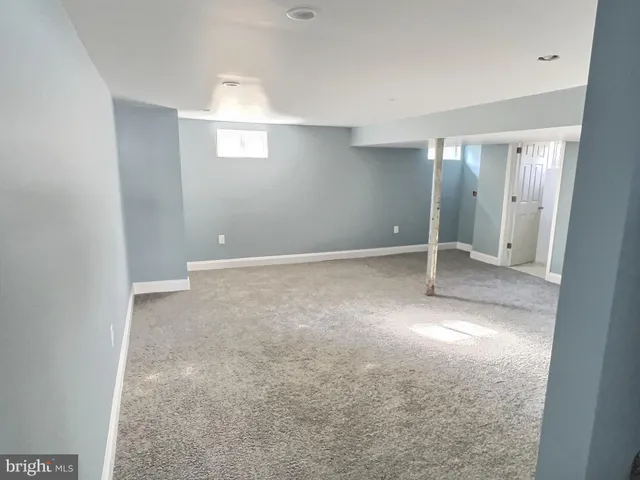 an empty room with windows and entrance to other room