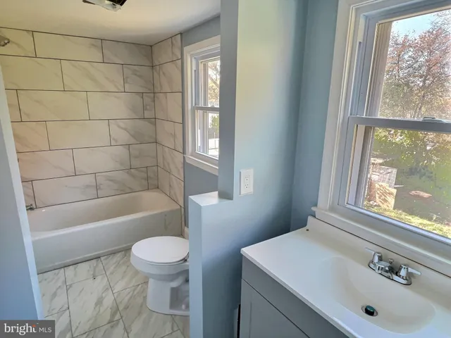 a bathroom with a sink a toilet and tub