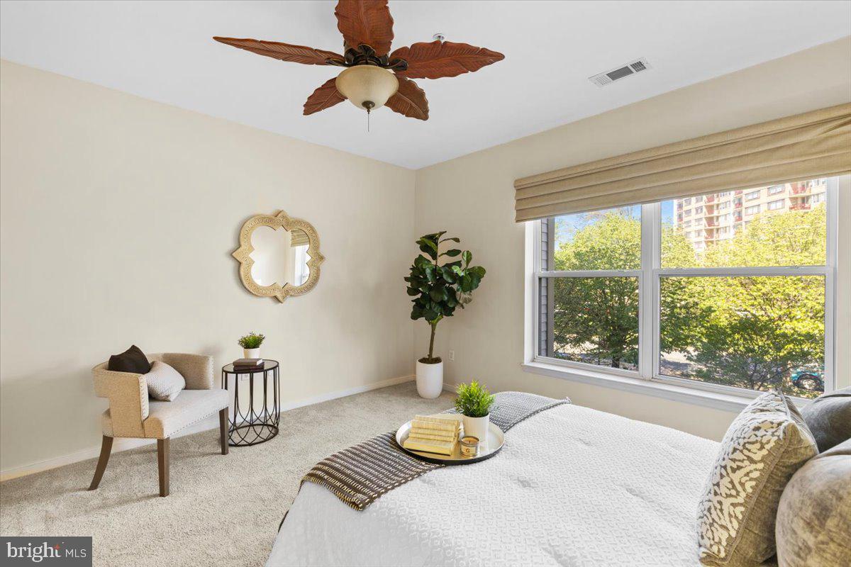 8045 Newell Street, Unit 107 Silver Spring, MD 20910 - Photo 28 of 75 a bedroom with a bed and a large window