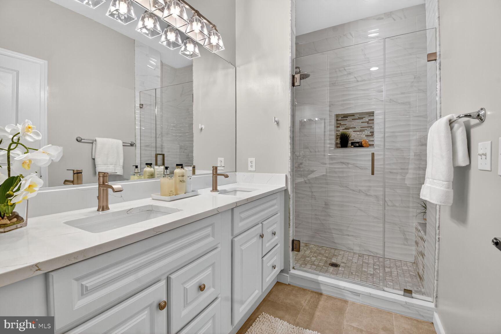 8045 Newell Street, Unit 107 Silver Spring, MD 20910 - Photo 32 of 75 a bathroom with a double vanity sink mirror and shower