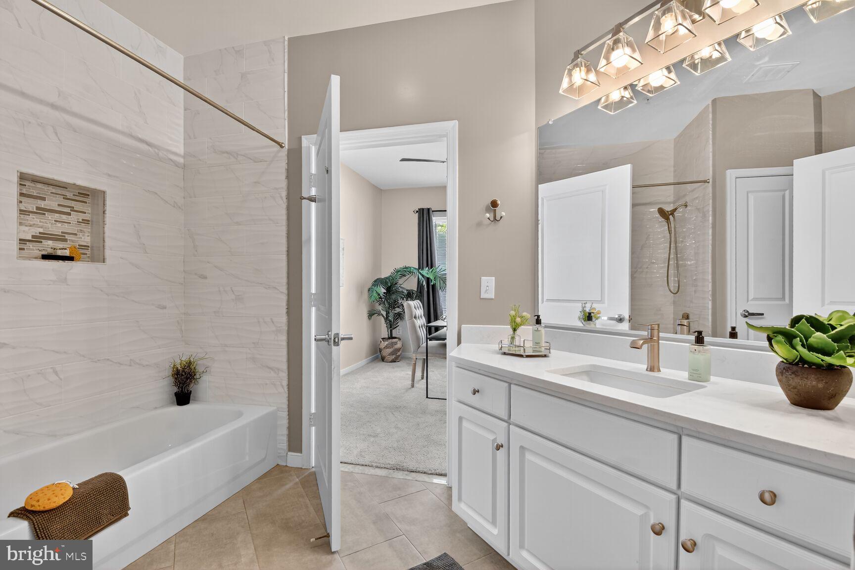 8045 Newell Street, Unit 107 Silver Spring, MD 20910 - Photo 36 of 75 a bathroom with a tub sink and mirror