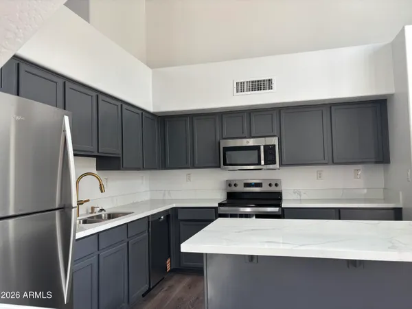 a kitchen with a refrigerator a microwave a sink and cabinets