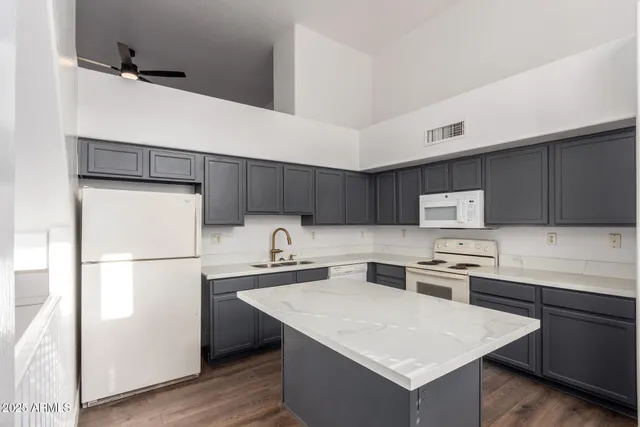 a kitchen with stainless steel appliances a refrigerator a sink a stove a microwave and wooden cabinets