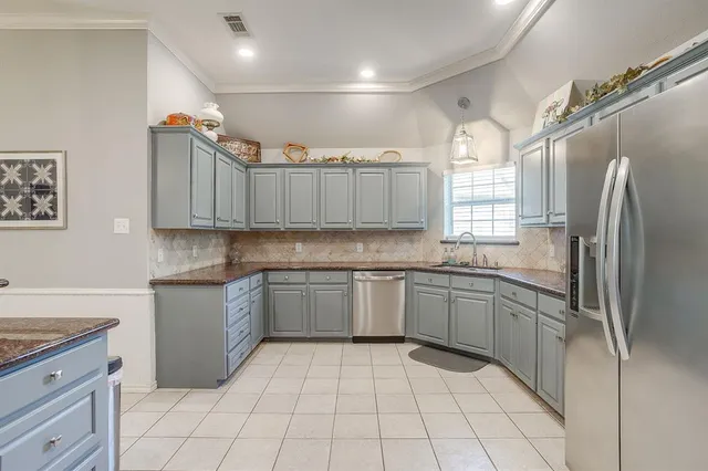 a kitchen with stainless steel appliances granite countertop a refrigerator and a sink