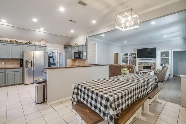 a large kitchen with a table and refrigerator