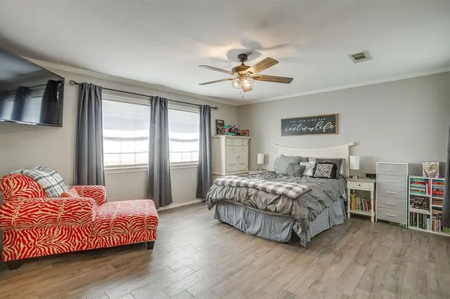 a bedroom with a large bed chandelier and a window