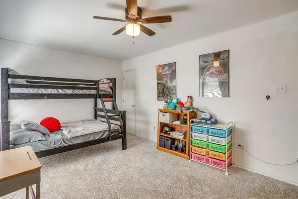 a bedroom with furniture and a fan