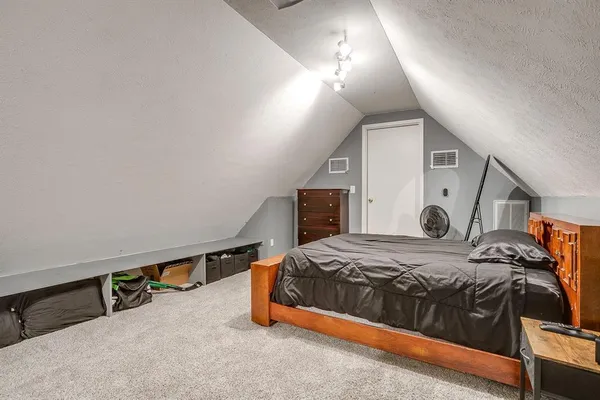 a bedroom with a bed and a lamp with the wooden floor