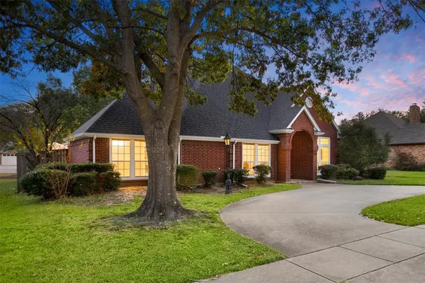 a front view of a house with a yard and trees