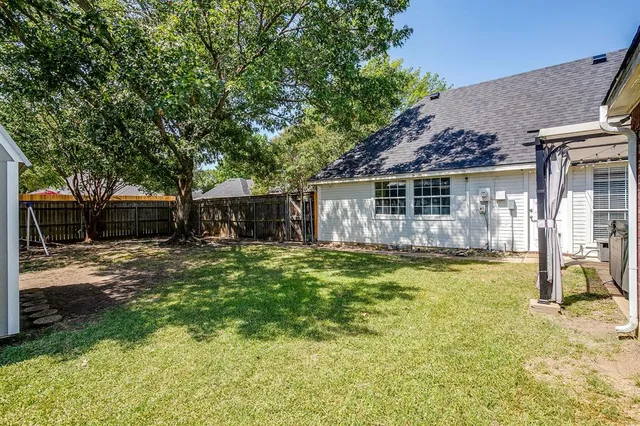 a view of a house with backyard and sitting area