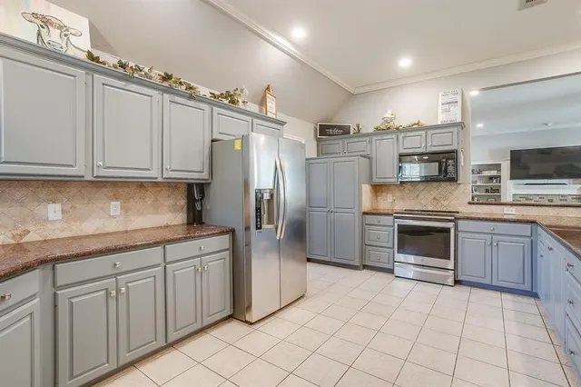 a kitchen with stainless steel appliances granite countertop a refrigerator and a stove top oven