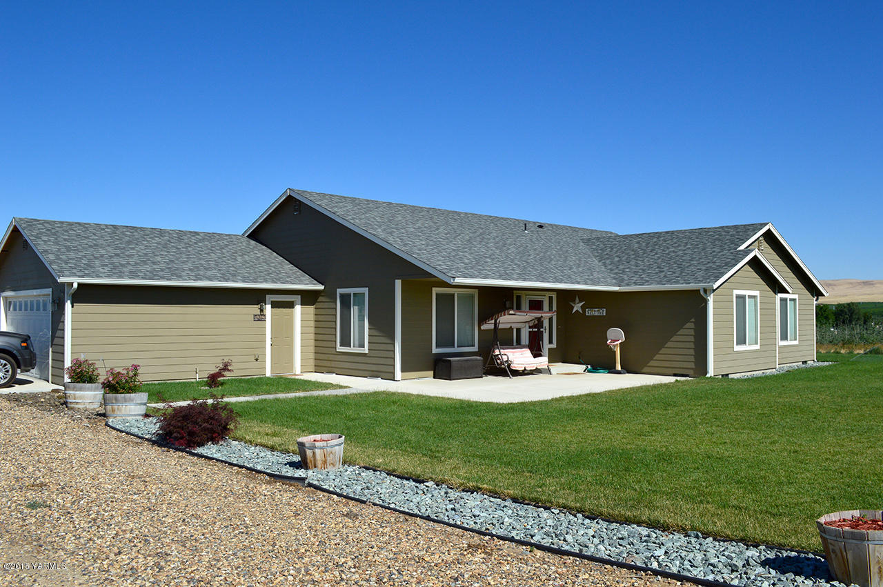 328 Cornue Road Zillah, WA 98953 - Photo 1 of 21 a front view of a house with a yard and garage