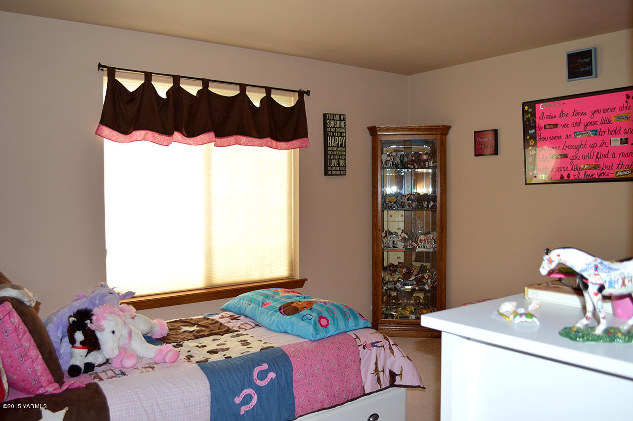 328 Cornue Road Zillah, WA 98953 - Photo 14 of 21 a bed room with a bed and a baby bed