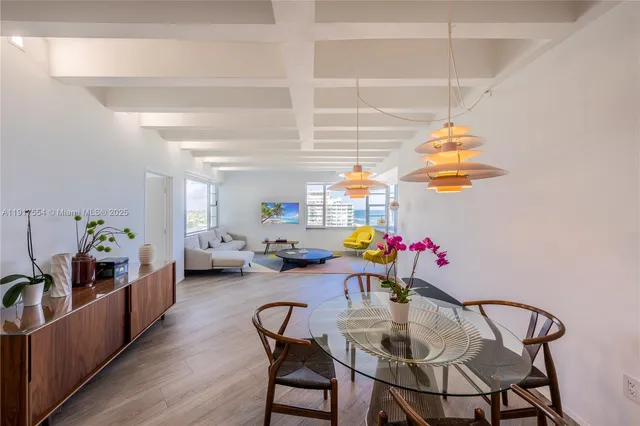 a view of a dining room with furniture and potted plants