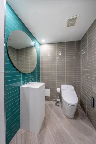 a bathroom with a toilet and a mirror