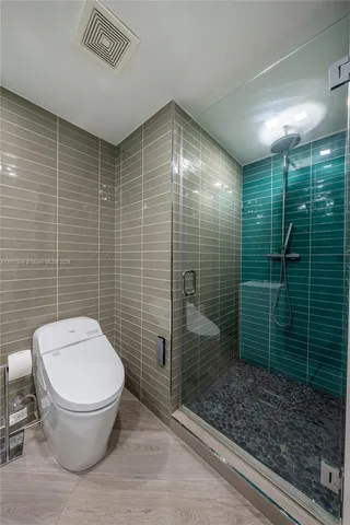 a bathroom with a toilet and a shower