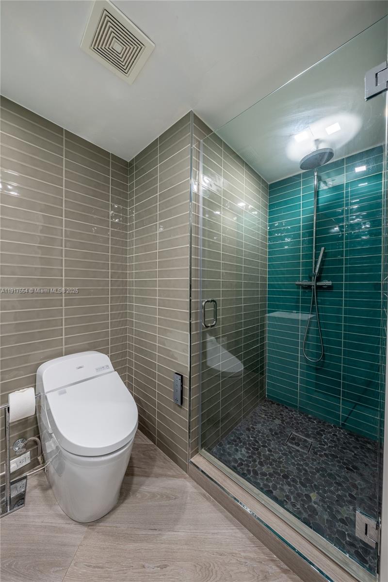5255 Collins Avenue, Unit 12F Miami Beach, FL 33140 - Photo 16 of 45 a bathroom with a toilet and a shower