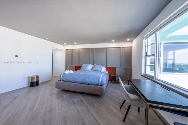 a spacious bedroom with a bed and a large window