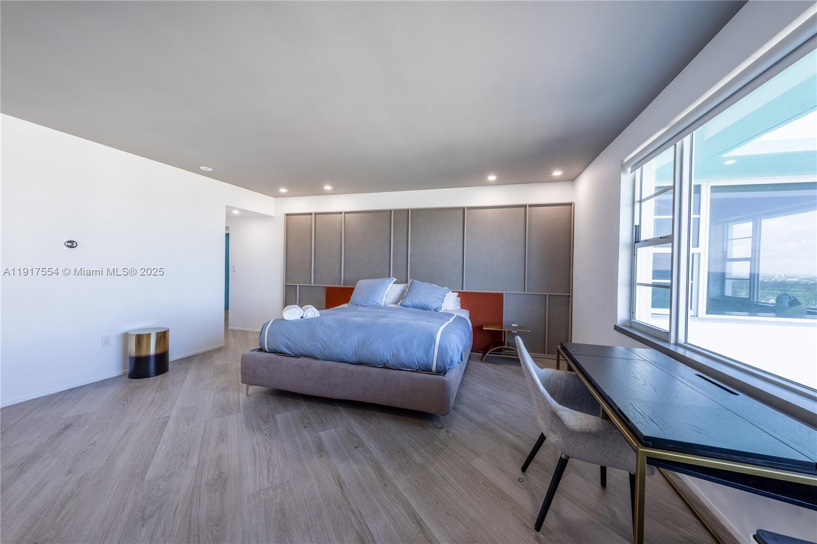5255 Collins Avenue, Unit 12F Miami Beach, FL 33140 - Photo 19 of 45 a spacious bedroom with a bed and a large window