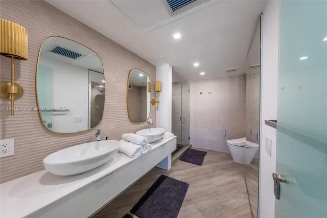 a bathroom with a double vanity sink toilet and a mirror