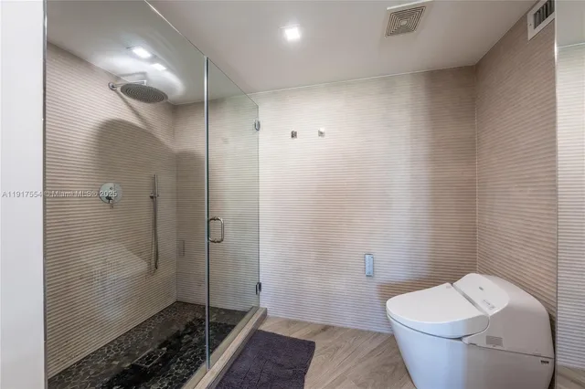 a bathroom with a granite countertop toilet and a shower
