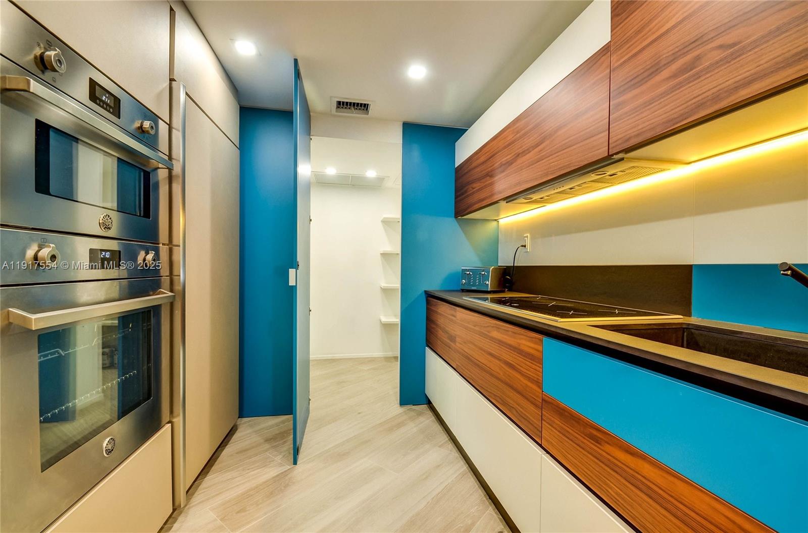 5255 Collins Avenue, Unit 12F Miami Beach, FL 33140 - Photo 9 of 45 a kitchen with stainless steel appliances a refrigerator and a stove