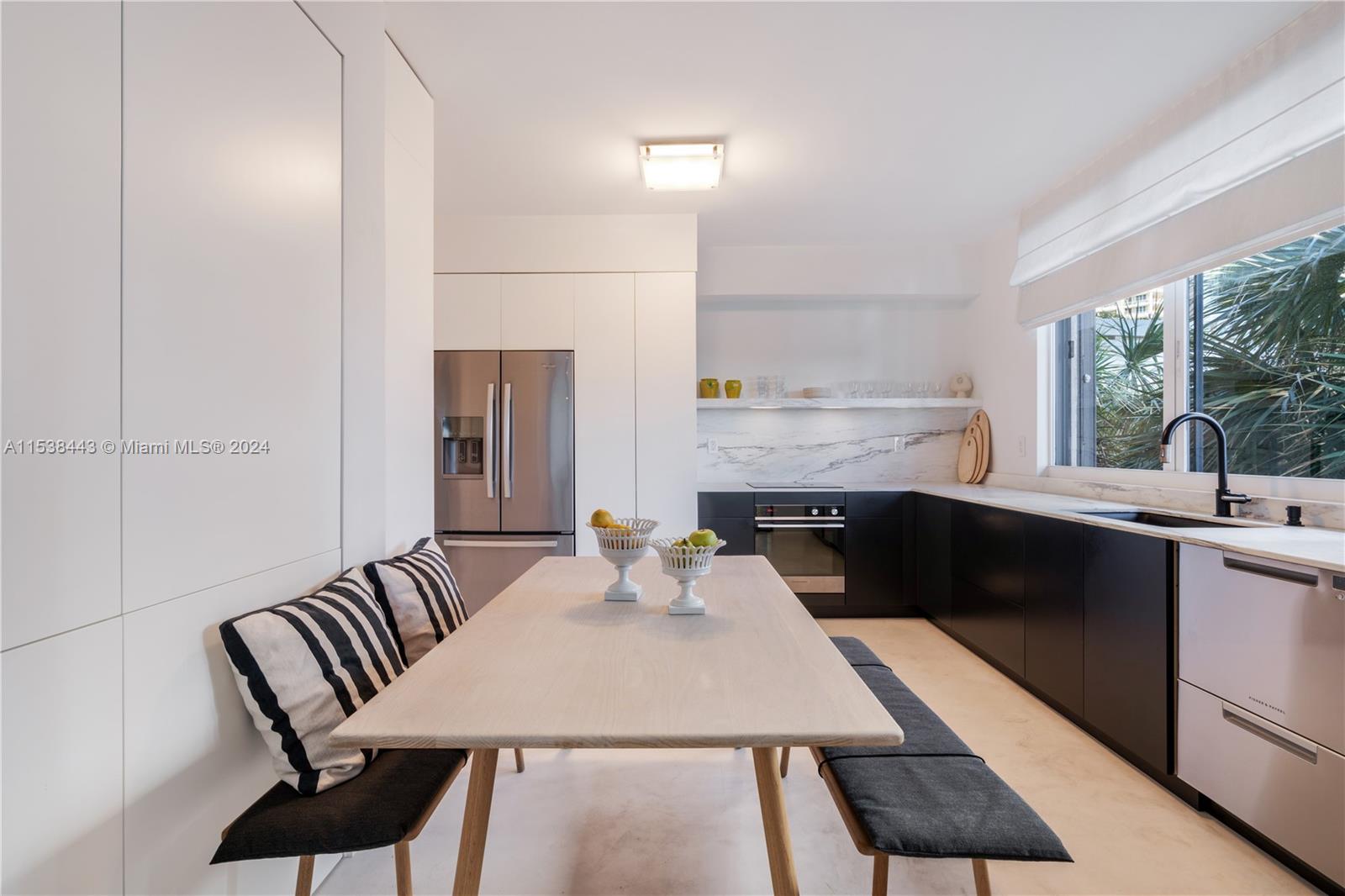 540 Brickell Key Drive, Unit 320 Miami, FL 33131 - Photo 11 of 32 a kitchen with a table chairs a sink dishwasher window and cabinets