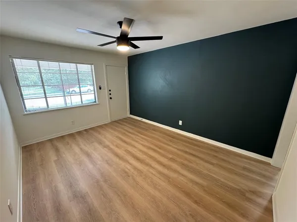 an empty room with windows and fan